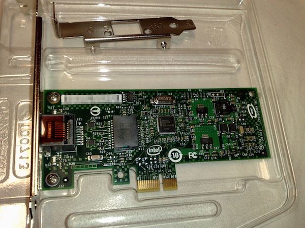 Photograph of an NIC PCI express card. It is a rectangular board with with gold pins protruding from the bottom of the card.